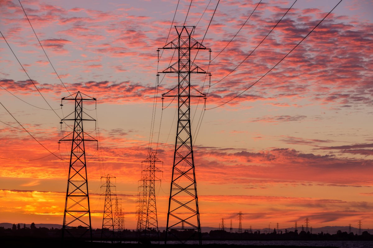 Electricity pylon towers with a sunset in the background